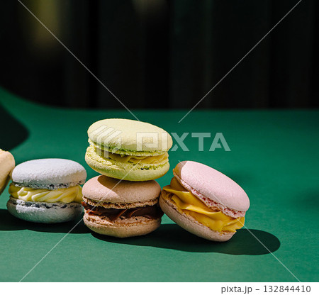 Colorful macaron selection on green surface with vibrant background 132844410