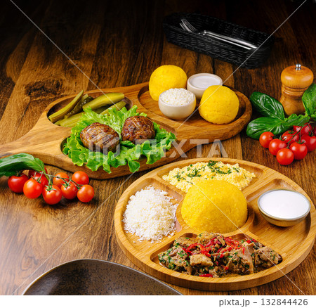 Delicious traditional meal served on wooden plates with fresh ingredients Delicious traditional meal served on wooden plates with fresh ingredients 132844426