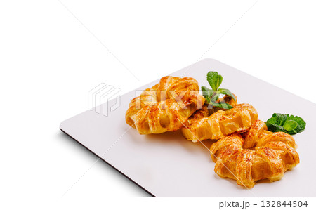 Freshly baked pastries displayed on a white plate with mint garnish Freshly baked pastries displayed on a white plate with mint garnish 132844504