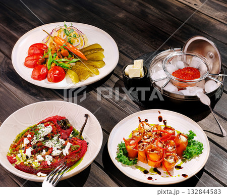 Variety of colorful dishes served at a rustic dining table 132844583