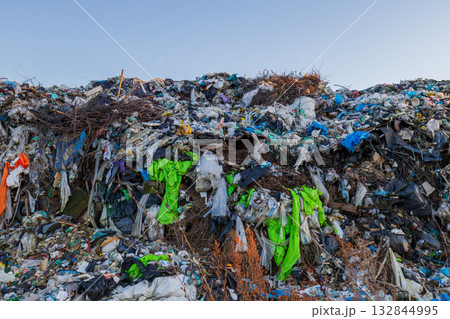 A vast landfill site full of various types of waste, including plastic, clothing, and other debris, highlights pollution and ecological issues A vast landfill site full of various types of waste, including plastic, clothing, and other debris, highlights pollution and ecological issues 132844995