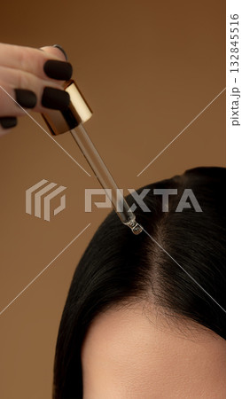 Dropper applying serum to scalp for professional trichology treatment Dropper applying serum to scalp for professional trichology treatment 132845516