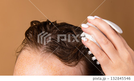 Scalp exfoliation with massage brush and foam during washing process Scalp exfoliation with massage brush and foam during washing process 132845546