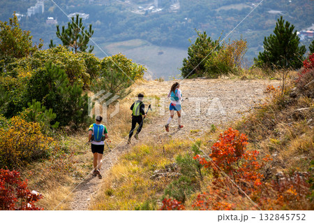 Group three athletes running mountain marathon in fall Group three athletes running mountain marathon in fall 132845752