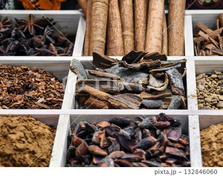 Colorful spice assortment displayed in wooden compartments at a local market in the afternoon Colorful spice assortment displayed in wooden compartments at a local market in the afternoon 132846060