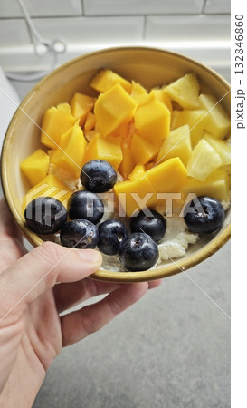 Colorful breakfast bowl with mango, pineapple, and blueberries on cottage cheese. Concept of healthy eating, freshness and balanced morning nutrition Colorful breakfast bowl with mango, pineapple, and blueberries on cottage cheese. Concept of healthy eating, freshness and balanced morning nutrition 132846860