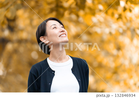 秋の公園を散歩する女性 132846934