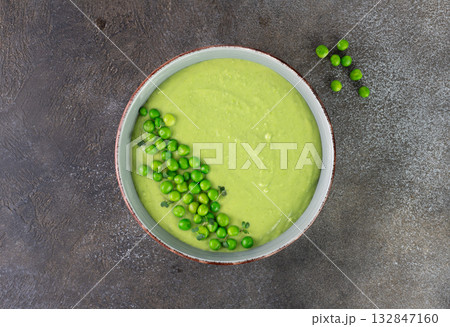 Green pea cream soup with croutons on a brown table. Top view 132847160