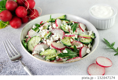 Vegetarian salad of radishes, cottage cheese, sour cream and arugula on a gray background. Top view. Vegetarian salad of radishes, cottage cheese, sour cream and arugula on a gray background. Top view. 132847174