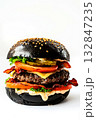Black burger with beef, cheese, fresh vegetables, bacon on a white background. Fast food. Copy space. 132847235
