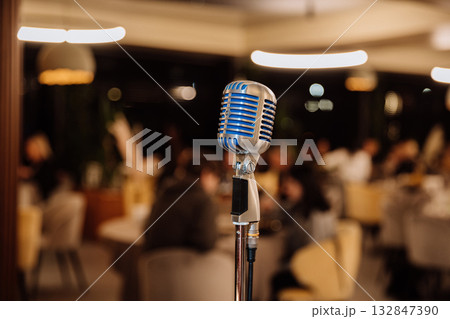 Retro microphone on stage in cozy restaurant, ready for live music, speech or standup show Retro microphone on stage in cozy restaurant, ready for live music, speech or standup show 132847390