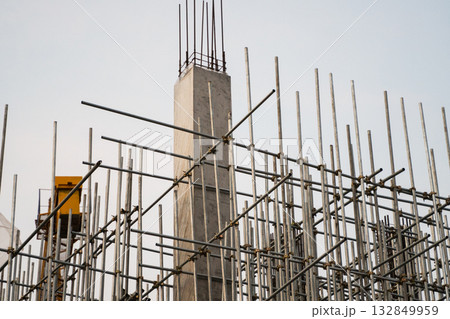 Vertical concrete column and scaffolding structure on industrial construction site outdoors 132849959