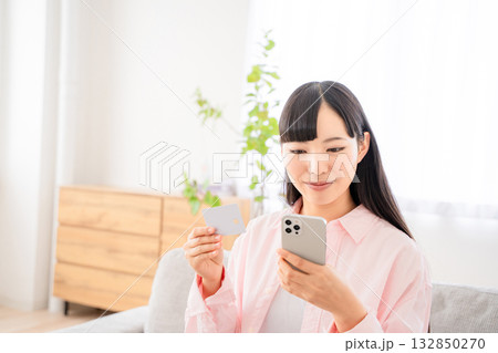 スマホでネットショッピングをする若い女性 スマホでネットショッピングをする若い女性 132850270