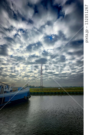 A Serene and Beautiful River Landscape Accompanied by Dramatic Clouds in the Sky Above 132851267