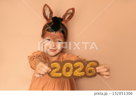 A girl in a horse costume with a painted muzzle and a headband in the form of ears, which depicts the numbers 2026. The symbol of the new year according to the Eastern lunar calendar 132851306