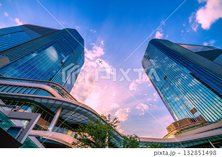 日本の東京都市景観　高輪ゲートウェイ駅前の高輪ゲートウェイシティなどを望む。上空に航空機（E2連続） 132851498