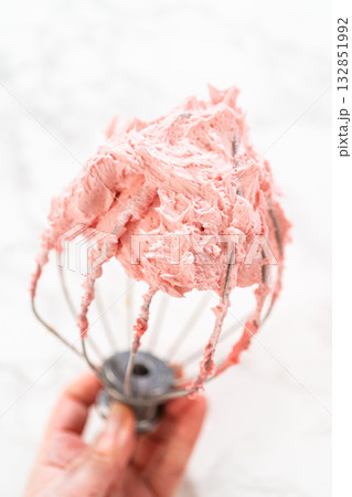 Detailed image of raspberry buttercream on a whisk attachment, showcasing the frosting texture and fluffiness from the Easter Cookie Sandwich with Raspberry Buttercream recipe. Ideal for baking 132851992