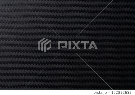 Textured black surface with geometric pattern of raised diamonds 132852652