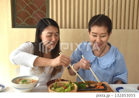 Asian elder woman and daughter have eating Japanese food for lunch by chopsticks in restaurant 132853055