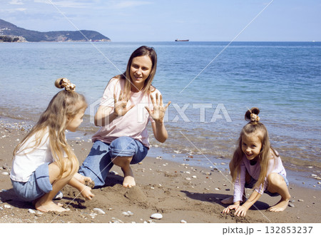 mother with twins daughters on beach mother with twins daughters on beach 132853237