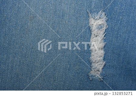 Ripped blue hipster jeans material. Destroyed denim Cloth texture. Close up. 132853271