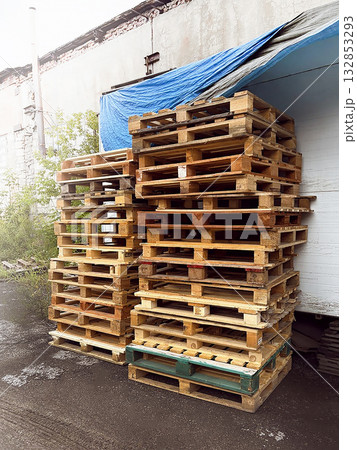 Tall stack of wooden pallets stored outside, vertical photo Tall stack of wooden pallets stored outside, vertical photo 132853293