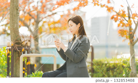 紅葉の街路樹と女性・ビジネスウーマン 紅葉の街路樹と女性・ビジネスウーマン 132853408