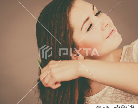 Happy woman brushing her hair 132853442