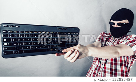 Man wearing balaclava shooting from keyboard 132853487