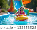 Young girl on water slide at aquapark. Summer holiday. 132853528
