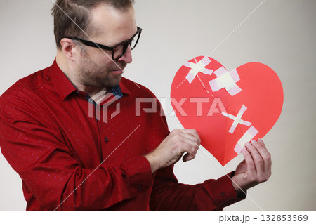 Sad adult man holding broken heart 132853569