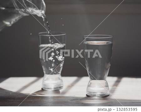 Glass of water on a wooden table Glass of water on a wooden table 132853595