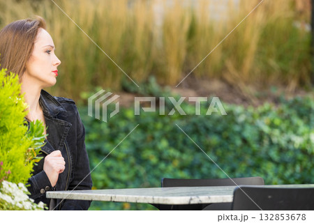 Woman waiting in outdoor restaurant cafe. 132853678