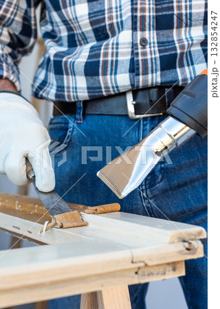 Carpenter at work, restoring an old wooden window. Carpentry. 132854247