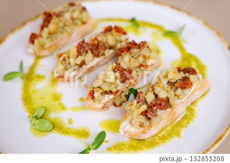 This bruschetta features a delicious combination of fresh mozzarella and tomatoes with pesto. 132855208