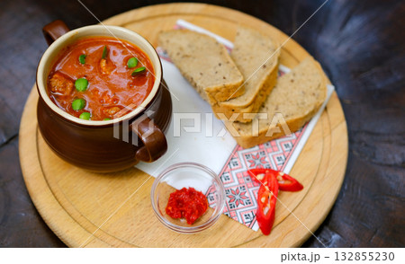 Traditional Indian Punjabi dish Dal makhani with lentils and beans in black bowl served with naan flat bread, fresh cilantro and two spoons on blue concrete rustic table top view. Space for text 132855230