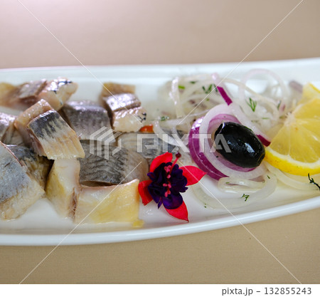 Marinated herring fillets with dill, onion rings, peppercorns and lemon isolated on white, top view 132855243