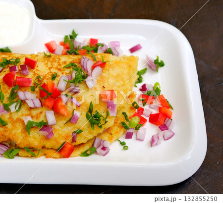 A photograph of a perfectly cooked omelet on a white ceramic plate A photograph of a perfectly cooked omelet on a white ceramic plate 132855250