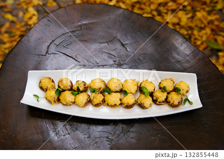 top view of stuffed mushrooms platter with cheese on rustic background top view of stuffed mushrooms platter with cheese on rustic background 132855448