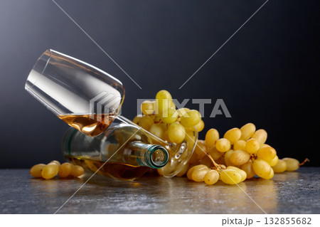 Grapes and white wine on a black background. Grapes and white wine on a black background. 132855682