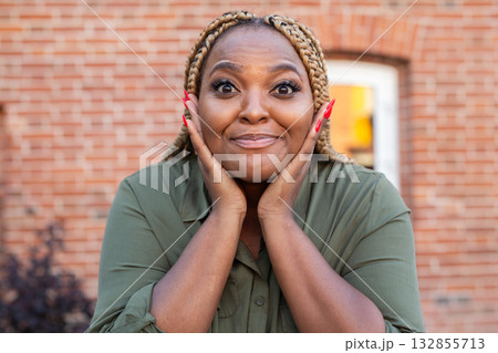 Portrait of african american woman expressing amazement with face gesture. Humor, surprise and emotional authenticity in candid moment. 132855713