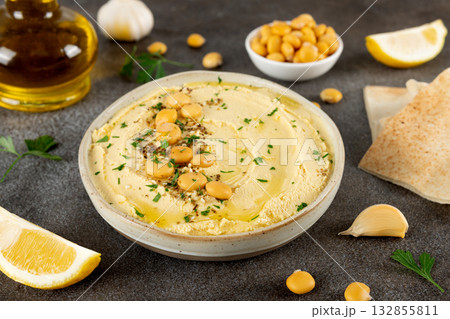 Creamy lupini bean hummus with olive oil, garlic, lemon and herbs in a ceramic bowl. Healthy vegan dip. Close-up. Creamy lupini bean hummus with olive oil, garlic, lemon and herbs in a ceramic bowl. Healthy vegan dip. Close-up. 132855811