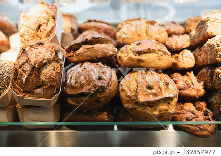 A large selection of fluffy French breads with yeast, grains, and figs on the counter at the bakery 132857927