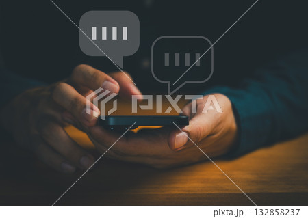 Close-up of hands using smartphone with chat bubbles, symbolizing online messaging, instant communication, mobile chat apps, digital conversation, customer support, social interaction in technology. 132858237