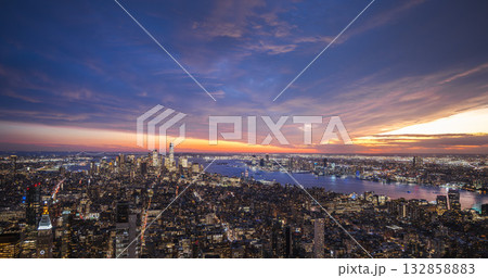 New York City skyline at twilight with illuminated buildings and colorful sunset sky over the Hudson River 132858883