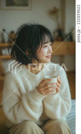 リビングでドリンクを飲んで微笑む女性 リビングでドリンクを飲んで微笑む女性 132859022