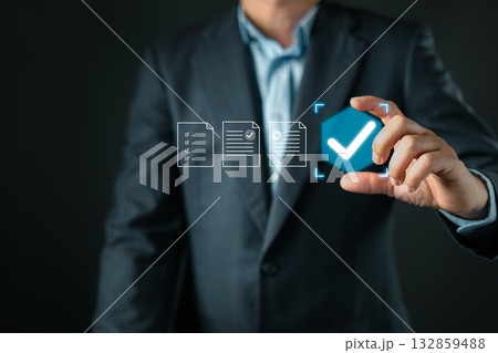 A businessman in a suit selects a glowing blue checkmark icon among digital document icons, representing successful validation, approval, completion, and verified document processing. 132859488