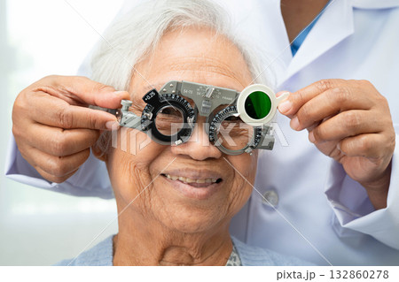 Asian senior woman wearing ophthalmic vision eye test and using optical trial frame. Asian senior woman wearing ophthalmic vision eye test and using optical trial frame. 132860278