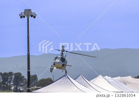 A tourist helicopter in flight around a sporting event A tourist helicopter in flight around a sporting event 132861054