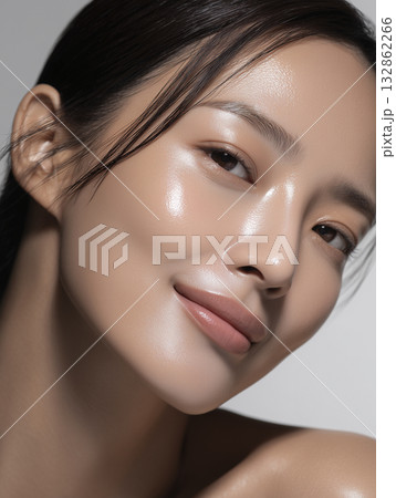 美容液を塗って肌に潤いがある女性の顔のアップ 132862266